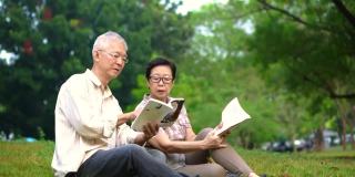 一对亚洲老夫妇在公园看书。花宝贵的时间，永远不要停止学习新东西