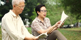 一对亚洲老夫妇在公园看书。花宝贵的时间，永远不要停止学习新东西