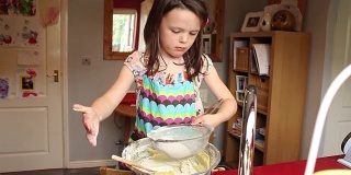 小女孩在家里的厨房里烤蛋糕