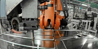 LD工业机器人在工厂里将一个模压的金属板固定在底座上