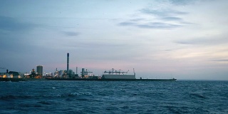 黄昏时分，瑞典赫尔辛堡的工业港。多风的天气，海浪
