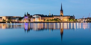 斯德哥尔摩城市夏夜4K时间流逝倾斜。里达霍曼岛的城市景观，倒影在水中