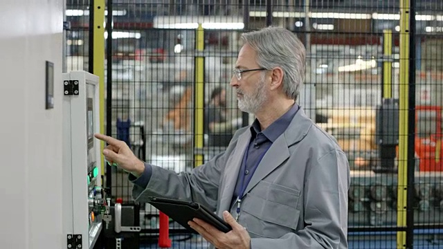 男性工程师使用触摸屏输入数据，并在他手中的平板电脑上反复检查插入的数值