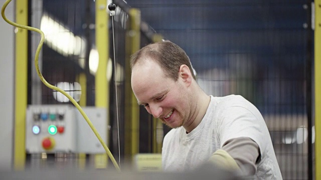 男员工微笑着在工厂里工作