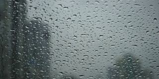 在汽车挡风玻璃刮水器雨点滑下车内的雨天视图的缓慢运动