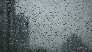 在汽车挡风玻璃刮水器雨点滑下车内的雨天视图的缓慢运动视频素材模板下载