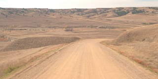 FPV:在炎热的日子里沿着蜿蜒的土路穿过草原沙漠景观