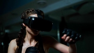 年轻迷人的女子拳击在VR 360耳机训练踢在虚拟现实。Slowmotion拍摄视频素材模板下载
