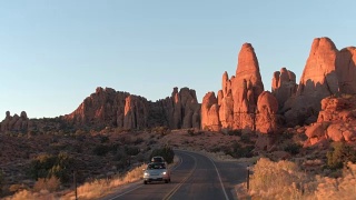 日落时分，驾车穿过风景如画的红石拱门国家公园视频素材模板下载