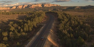 图片:一辆黑色SUV驶向阳光明媚的犹他州的平顶山