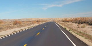 FPV:在美国犹他州的秋天，沿着空旷的道路穿过广阔的沙漠