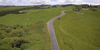 公路旅行在绿色草地在罗托鲁瓦，新西兰从空中看