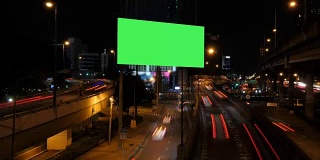 夜间有车流的绿屏广告。