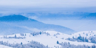 山峰上的雪被风吹走了。冬天的风景。天很冷，下着雪。