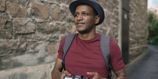 非洲快乐的游客用他的单反相机拍照。在欧洲旅行的年轻人