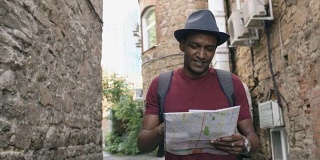 斯坦尼康镜头的非洲裔美国游客走和看纸城市地图寻找方向到著名的地方