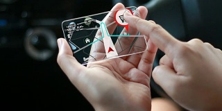 近距离拍摄的女人的手使用透明玻璃智能手机与gps导航交通到购物中心在汽车未来