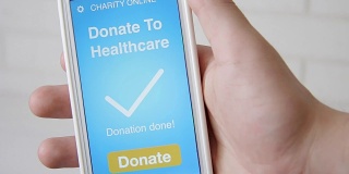 一名男子通过智能手机上的慈善应用为医疗机构在线捐款