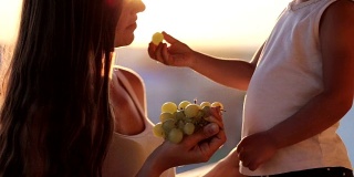 日落时分，妈妈和小女儿在阳台上吃葡萄