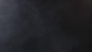 浓密的蓬松的白色烟雾和雾在黑色的背景上，抽象的烟雾云视频素材模板下载