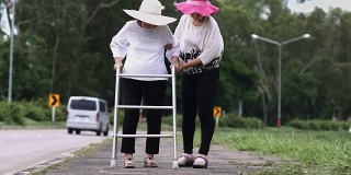 女儿照顾在强烈阳光下行走的老妇人。