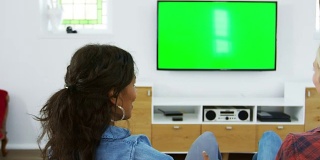 女性朋友坐在沙发上看电视的后视图