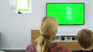 家庭坐在沙发上看电视的后视图视频素材模板下载