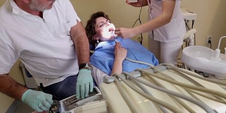 牙医治疗女病人牙齿，手持射击