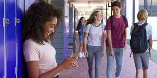 黑人少女在学校走廊使用智能手机