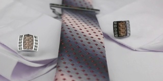 多莉。特写打结的粉红色领带，袖扣和领带夹上白衬衫。