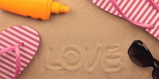 爱情，用手铭刻在沙滩上，点缀在沙滩上。符号和符号娱乐。