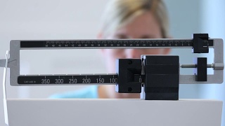 在秤上称体重的女人视频素材模板下载