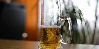 啤酒倒在桌子上的半空杯子里