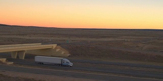 天线:在金色的夕阳下，货车在高速公路上运送货物