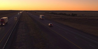 汽车和货车在高速公路上行驶。黎明时货物运输