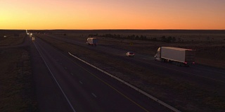 汽车和货车在高速公路上行驶。黎明时货物运输