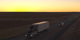 汽车和半卡车在公路上行驶，在日落时分运送货物