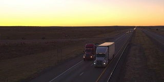 图片:黎明时分，卡车和汽车在繁忙的公路上行驶