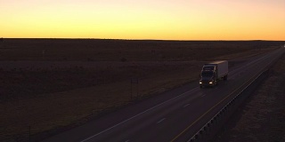 航拍图:黎明时分，卡车货运和汽车在公路上行驶