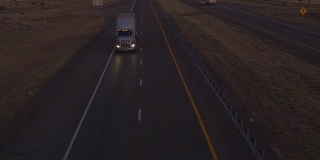 航拍:黄昏时分，公路上货运卡车和汽车的交通