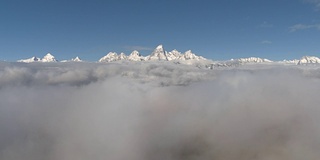 空中:雄伟的雪山大提顿山峰消失在雾和云中