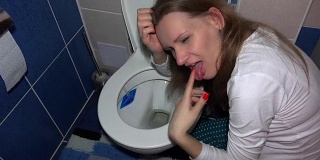 早上在浴室呕吐的女人。可悲的女性妊娠期疾病