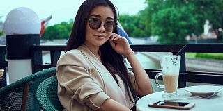 漂亮可爱的亚洲女人，喝着咖啡