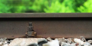 当火车运行时，装有固定螺钉的铁路轨道关闭