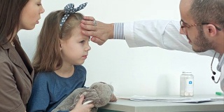 男儿科医生检查小女孩的头部发烧