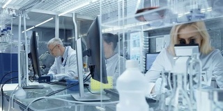在一个新的高科技实验室使用显微镜和医学数据的研究科学家团队。