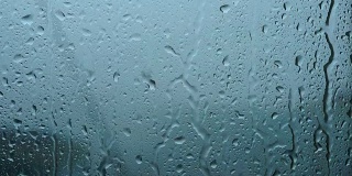 一场大雨带着一阵阵大风从窗户里倾泻而出。溪水迅速地从玻璃杯中流下。夏季飓风伴有瓢泼大雨。