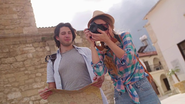 游客拿着地图和相机在老城区拍照
