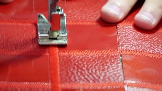 工厂生产的概念真皮制品。在缝纫机上缝合红色皮革视频素材模板下载