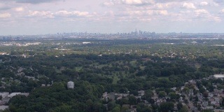 航拍:在豪华郊区上空飞行，俯瞰著名的纽约市天际线